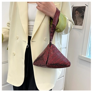 Chic red rhinestone pyramid handbag held by a model in a minimal cream blazer outfit