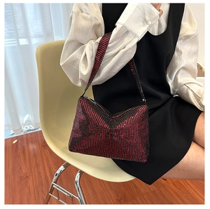 Close-up of red and black sequined shoulder bag with zipper detail and strap