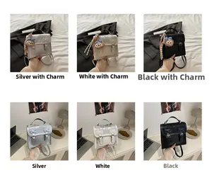 Detail view of stylish small backpacks in silver, white, and black with cute bear charms