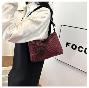 Red-black gradient baguette bag with shimmering rhinestones worn on shoulder