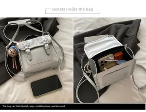 Silver-gray crossbody bag showing internal capacity for phone, lipstick, and keys