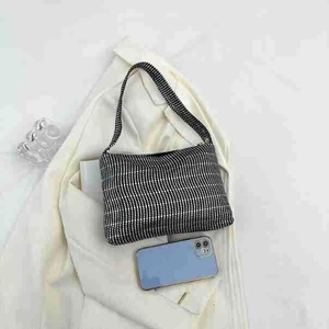 Close-up of black rhinestone shoulder bag with sparkly studs and size reference phone