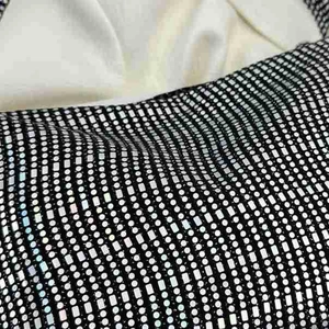 Detailed macro view of black canvas with geometric silver sequins and shimmering texture