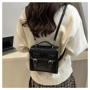 Rear view of a black bow backpack with polka dots and butterfly patterns on model
