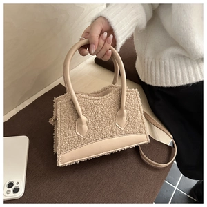 Detail view of beige faux fur handbag showing plush texture and smooth leather trim