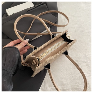 Vue de dessus d'un sac en peluche beige avec fermeture éclair dorée et intérieur spacieux