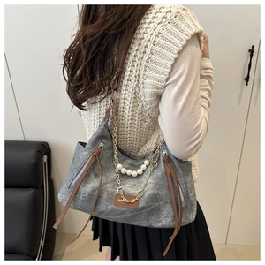 Detail of grey canvas tote with silver chain and white pearl charms on the front