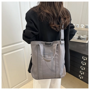 Vue détaillée arrière d'un grand sac fourre-tout en toile grise avec étiquette de mode