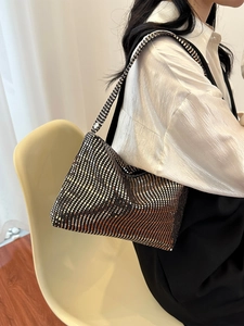 Chic sequined underarm bag with metallic glitter finish on model in modern room