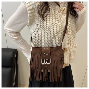 Detail of brown suede tassel shoulder bag with metallic buckle and bohemian fringe style