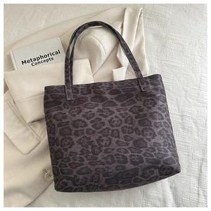 Detailed close-up of leopard print canvas tote bag on a stylish beige blazer background