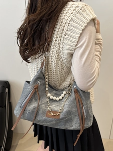 Gray canvas shoulder bag with pearl chain and leather tag shown on model back