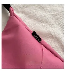 Detail of pink nylon dumpling bag with black SPORT label and high-quality stitching