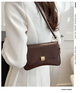 Detail of dark brown matte faux leather crossbody bag with gold square buckle closure