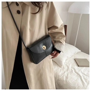 Detail showing a model wearing a black leather crossbody bag with a gold twist lock