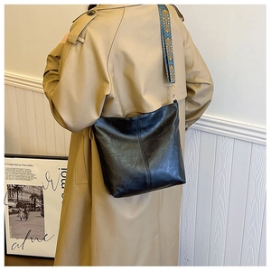Detail of black leather hobo bag with ethnic print strap and vintage Franz Kafka decor