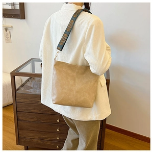 Detail of khaki bucket bag featuring vintage ethnic style embroidered wide shoulder strap