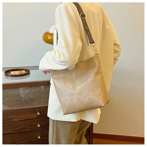 Detail of khaki leather bucket bag with retro geometric pattern wide shoulder strap
