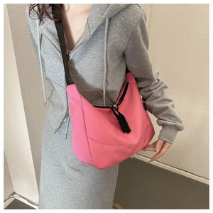 Detailed close-up of a pink nylon crescent bag with black zipper and woven pullers