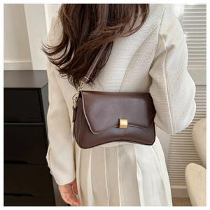 Detail of dark brown leather baguette bag with premium gold rectangle metal clasp