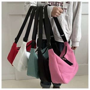 Detailed close-up of nylon dumpling bags in multiple colors with adjustable straps
