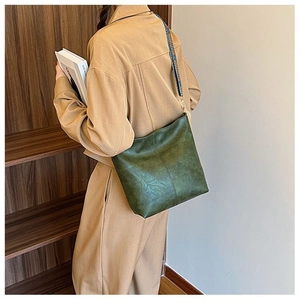 Dark green vintage tote bag with retro leather texture and a colorful woven shoulder strap