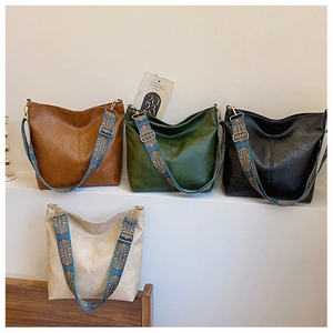 Detail of large vintage bucket bags in four colors with bohemian patterned wide straps