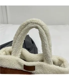Detail of soft shearling handles and brown leather logo tag on a fuzzy bucket bag