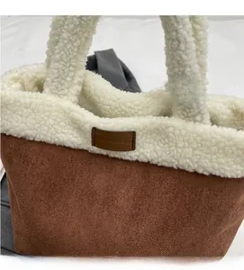 Detail of the textured faux shearling trim and brown suede material on the tote bag