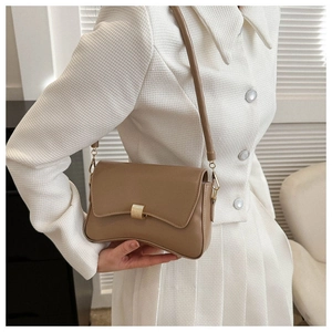 Close-up of khaki leather baguette bag with curved base and golden metal buckle