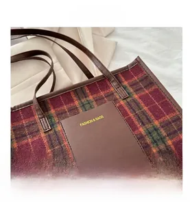 Detail of plaid tote bag featuring woolen fabric texture and leather front pocket