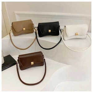 Close-up of four colors of minimalist underarm bags with gold buckles on white display steps
