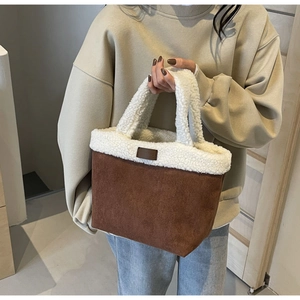 Detail of plush lamb wool tote bag featuring brown suede stitching and small leather tag