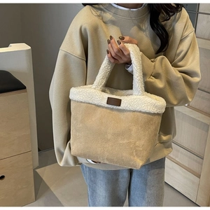 Detail of soft sherpa trim and suede texture on this winter bucket tote handbag