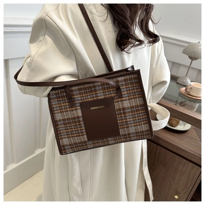 Classic checkered tote bag with leather strap shown in an elegant daily commute setting