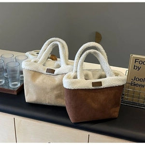 Detail of plush lamb wool and suede tote bags in beige and brown colors for winter