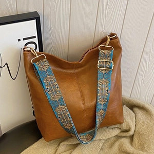 Brown large capacity leather bucket bag with vibrant ethnic style patterned shoulder strap