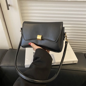 Minimalist black leather crossbody bag with gold rectangular buckle and adjustable strap