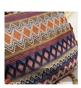 Close-up of bohemian woven bag with zigzag embroidery and decorative tassel details