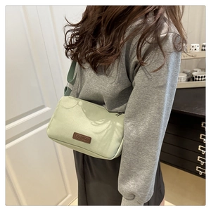 Détail du sac à bandoulière en nylon vert menthe avec sangle réglable et écusson de mode