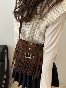 Brown suede crossbody bag with fringe details and top handle for autumn commute