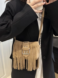 Brown suede tassel crossbody bag with silver buckle in a bohemian minimalist style