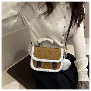 Detail of brown matte handbag with plush white faux fur trim and round coin purse charm