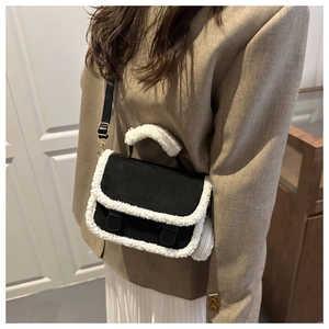 Detail of vintage square handbag with black matte texture and white faux shearling trim