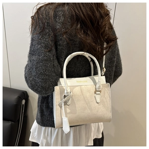 Vue détaillée du sac à bandoulière en cuir beige avec lettrage de mode imprimé