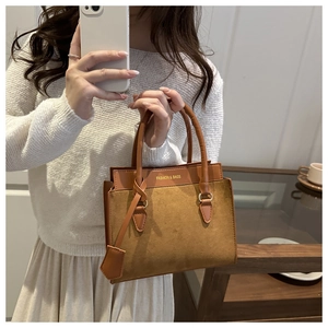 Détail du sac à main camel avec lettrage doré et finitions de coutures texturées