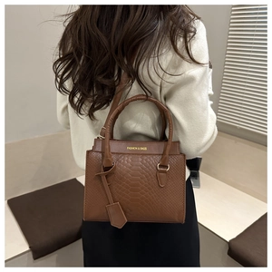 Close-up of brown snakeskin texture bag with dual handles and Fashion & Bags text