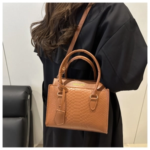 Detail of caramel brown faux crocodile leather bag with Fashion & Bags logo engraving