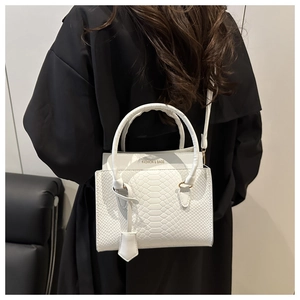 Detail of white snakeskin texture shoulder bag with Fashion & Bags print on black coat