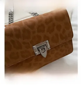 Detail of leopard print crossbody bag with silver chain strap and metallic swivel lock